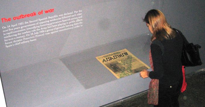 A lady looking at an historical newspaper at Jeu de Paume